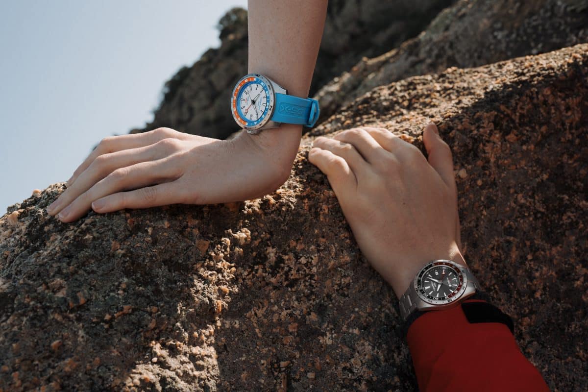 2 modeller fra Certina DS-X GMT på damearm og herrearm på en fjellknaus